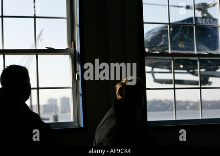 EC130 american eurocopter comes in to land watched by two passengers through window at liberty helicopters sightseeing tours Stock Photo