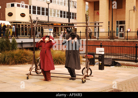 street performers hanging inside coats on a rail Stock Photo