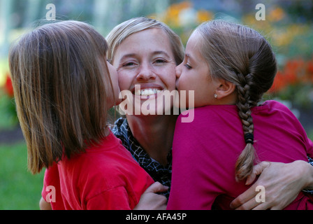 Woman and children giving her a kiss Stock Photo