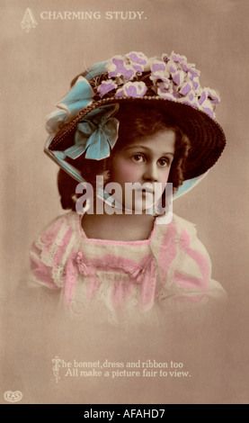 Tinted postcard pretty young girl in early 1900s wearing straw bonnet on postcard with note saying a charming study Stock Photo