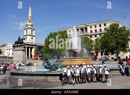 Tourists enjoying Trafalgar Square, bordered by The National Gallery and St Martin in the Fields Church. London England. Uk 2006 Stock Photo