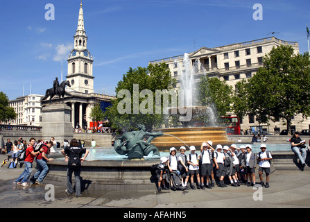 Children enjoying Trafalgar Square, bordered by The National Gallery and St Martin in the Fields Church. London England Stock Photo