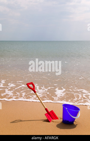 Bucket and spade on a sandy beach Stock Photo