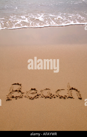 Beach written in sand at the beach Stock Photo