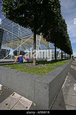 Illustration Airport Terminal: Traveller is sleeping at the parc of the modern Munich Airport building Stock Photo