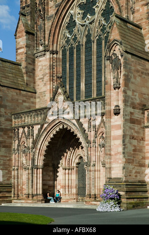 Two people sitting in doorway of Hereford cathedral England UK