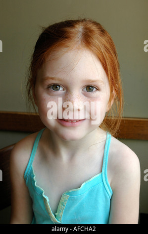 Portrait of Irish American redhead cute 5 five year old young girl with hazel green eyes smiling Stock Photo