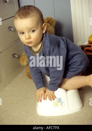 Toddler learning to use a potty Stock Photo
