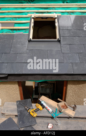 FITTING A VELUX WINDOW ON A SLATE ROOF UNDER CONSTRUCTION SHOWING THE BREATHABLE ROOFING FELT WITH WOODEN BATONS Stock Photo