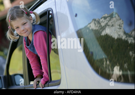 Young girl looking out the car window, reflection of mountains in the car window, Alpine road, Reiteralpe, Ramsau, Bavaria, Germ Stock Photo