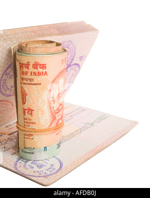 Roll of Indian Rupees on a British Passport with an Indian Visa. Isolated on White. Stock Photo