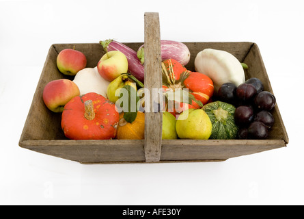 Harvest festival selection of seasonal fruit and vegtables presented in a wooden trug or basket Stock Photo