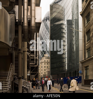 City workers businessman men people crowd street pedestrian road walking past Lloyds London England UK Stock Photo