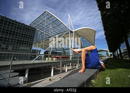 Illustration Airport Terminal 2: Traveler is sleeping at the parc of the modern Munich Airport building Stock Photo