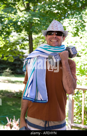 Man lifting weights wearing hat and sunglases Stock Photo