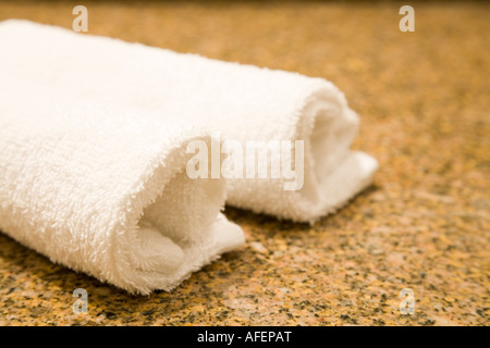 Fluffy white face towels on a granite counter