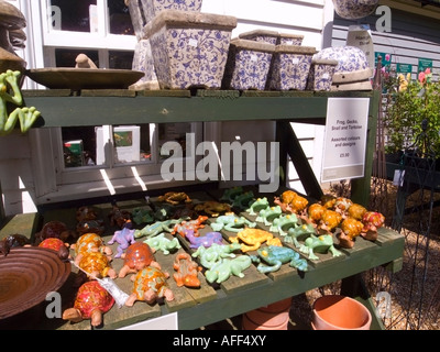 Colourful ceramic garden frogs and snails on sale in garden centre, UK Stock Photo