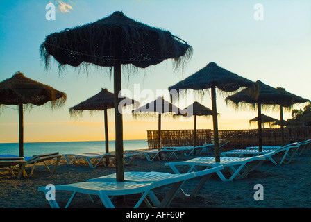Grass thatch umbrellas beach in Spain Stock Photo
