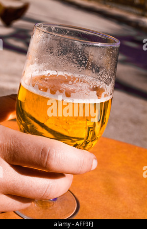 Female hand holding glass of cold beer Stock Photo