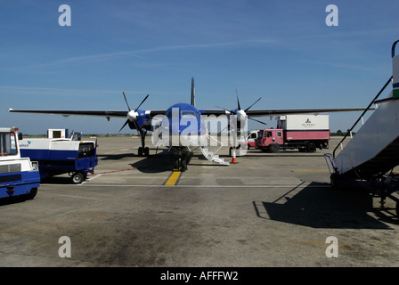KLM propeller plane on the stand with Alpha catering vehicle and other support vehicles in attendance Stock Photo