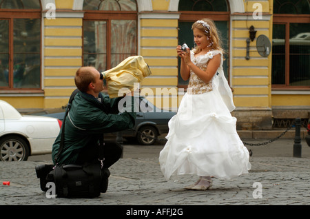 Cameraman shooting a video of a young bridesmaid wearing a white dress at a Russian wedding in St Petersburg Russia Stock Photo