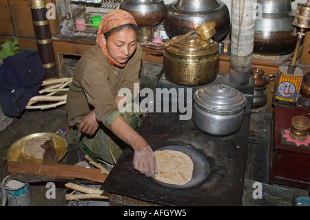 Woman baking chapatis in the kitchen, Nurla, Indus valley, Ladakh, Jammu and Kashmir, India Stock Photo