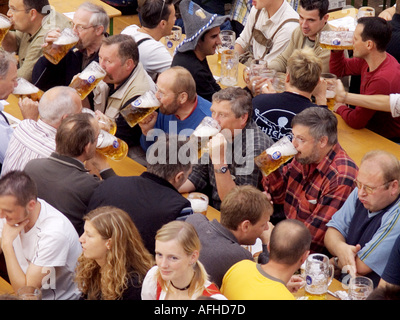 Europe Germany Munich Beer Festival Oktoberfest people dancing and drinking in tent hall and partying. Stock Photo