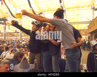 Europe Germany Munich Beer Festival Oktoberfest people dancing and drinking in tent hall and partying. Stock Photo