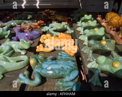 Colourful ceramic garden frogs and snails on sale in garden centre, UK Stock Photo