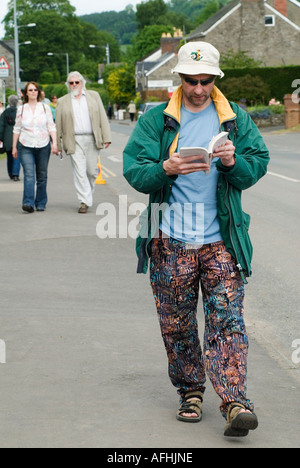 Reading a Book Walking. A man festival goer reads while he walks to Hay Festival Hay on Wye Powys Wales 2006 2000sHOMER SYKES Stock Photo