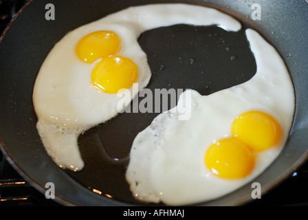 TWO DOUBLE YOKE FRIED EGG IN FRYING PAN Stock Photo
