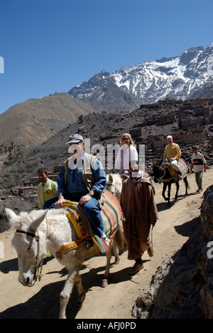 tourists on donkey ride Aroumd Around Aremd village Mizane Valley Toubkal National Park High Atlas Morocco North Africa Stock Photo