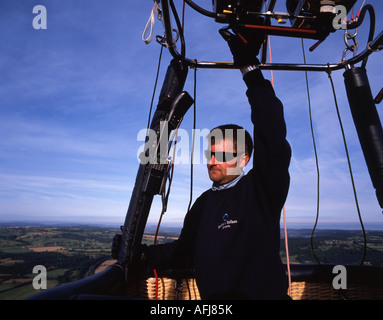 Hot air balloon looks for a landing site as he flies over the English countryside. Bristol International Balloon Festival. Stock Photo