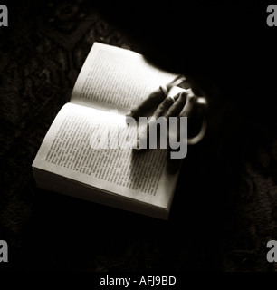 Hand of a man resting on open book Stock Photo