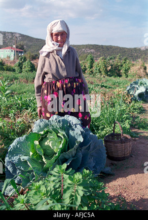 Older woman tending her garden of cabbages and other vegetable on a farm in remote Turkish village near Akyaka in South Western Stock Photo