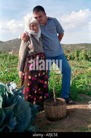 Older woman and grandson tending garden of cabbages and other vegetable on a farm in remote Turkish village near Akyaka in South Stock Photo