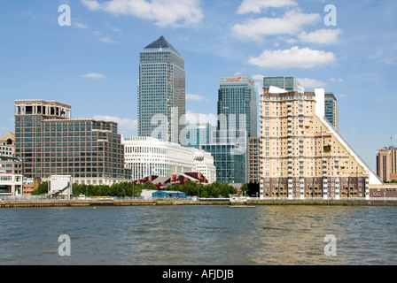 River Thames riverside apartment block close to the Docklands Canary Wharf redevelopment complex seen beyond Stock Photo