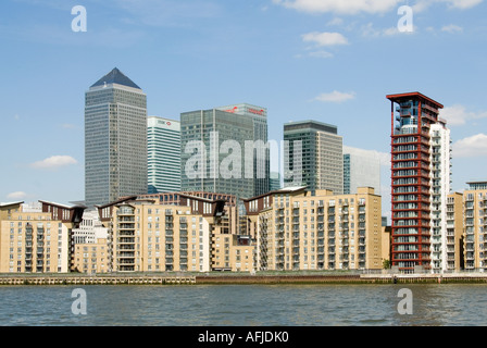River Thames riverside apartment blocks close to the Docklands Canary Wharf redevelopment complex seen beyond Stock Photo