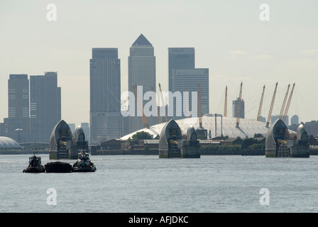 Thames Flood Barrier with Millennium Dome and Canary Wharf dockland towers skyline beyond Stock Photo