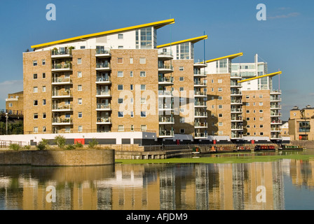 London Docklands Limehouse Basin Grand Union Canal reflections waterside repetitive apartment blocks narrowboat moorings Tower Hamlets East London UK Stock Photo