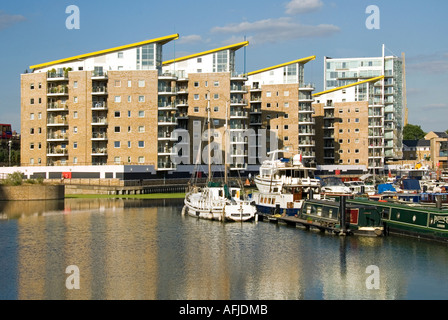 Limehouse basin modern residential apartment blocks with narrow canal boats at moorings Stock Photo