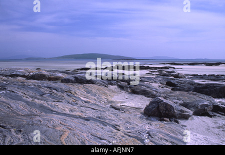 The island of Orasay viewed across the rock and white shell sand of Cille-Bharra. Stock Photo