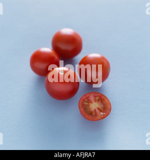 Five cherry tomatoes on a pale blue background Stock Photo