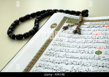 An open copy of the sacred text of Islam Qur'an with prayer beads called Tasbeeh over it Stock Photo