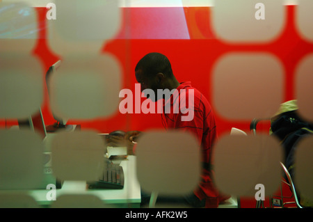 Black person working on computer seen through decorated glass window Stock Photo
