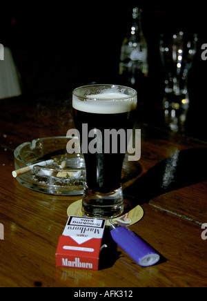Stout a packet of cigarettes and a lighter in a pub in Cork in Ireland New Irish laws ban smoking in pubs and bars Stock Photo