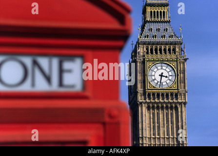 London's famous Clock Tower, Big Ben, is viewed from behind another English icon - the red phone booth. Stock Photo
