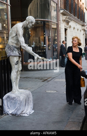 Living Statue Albermarle Street central London W1 England he hands out a leaflet and surprises a woman shopper. 2006 HOMER SYKES Stock Photo