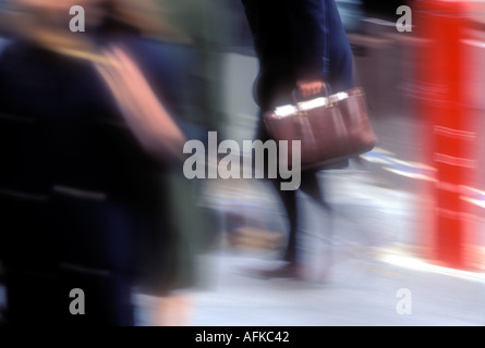 Blurred motion image of man with brief case walking in street Model Released Image Stock Photo