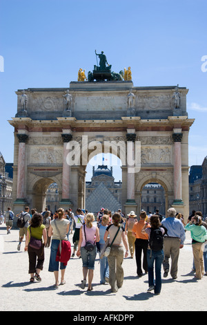 FRANCE Ile de France Paris People walking through Arc de Triomphe du Carrousel towards Louvre Museum from Tuileries Gardens Stock Photo